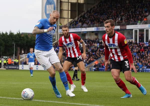 Marcus Maddison of Peterborough United takes on Harry Toffolo and Jorge Grant of Lincoln City. Photo: Joe Dent/theposh.com