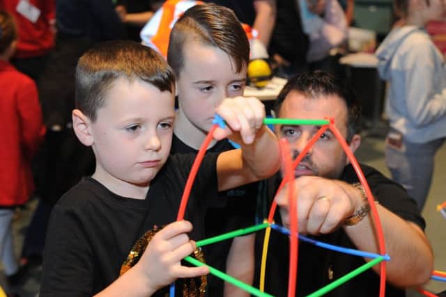 Peterborough STEM Festival 2019 at Kingsgate Centre. George Hendry with brother Alfie and dad Brian Hendry making a house structure. EMN-191013-141457009