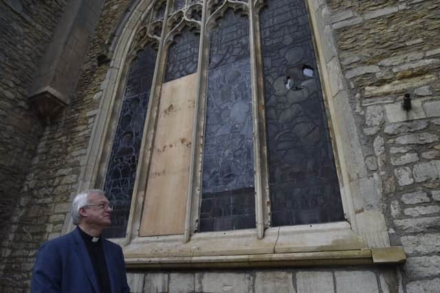 Canon Ian Black looking at broken wimdows at St John's church, Cathedral Square. EMN-191015-204628009