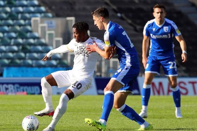 Siriki Dembele of Peterborough United battles with Alfie Jones of Gillingham. Photo: Joe Dent/theposh.com.