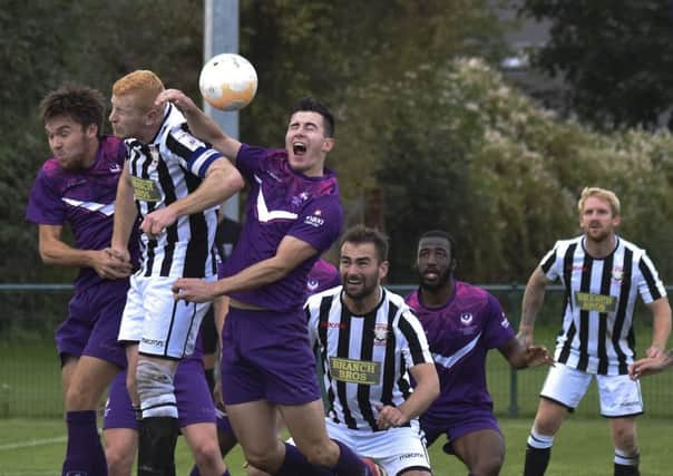 Peterborough Northern Star's Herbie Panting (stripes) challenges for a header in the match against Loughborough University. Photo: Brian Colbert.