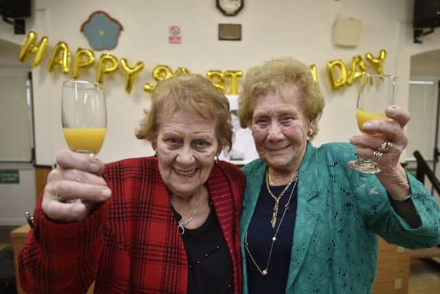 Twins Peggy Green (wearing red) and Kathleen Schneider (wearing green) celebrating their 90th birthdays at Coates village hall EMN-191027-095243009