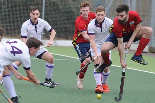 City of Peterborough's Ben Newman (red) takes evasive action as Durham University mount another attack. Photo: David Lowndes.