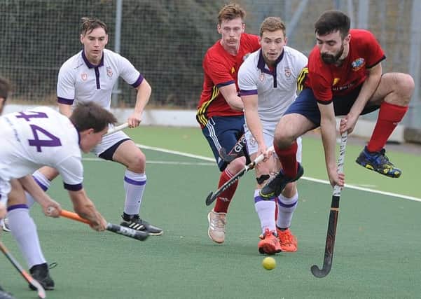 City of Peterborough's Ben Newman (red) takes evasive action as Durham University mount another attack. Photo: David Lowndes.