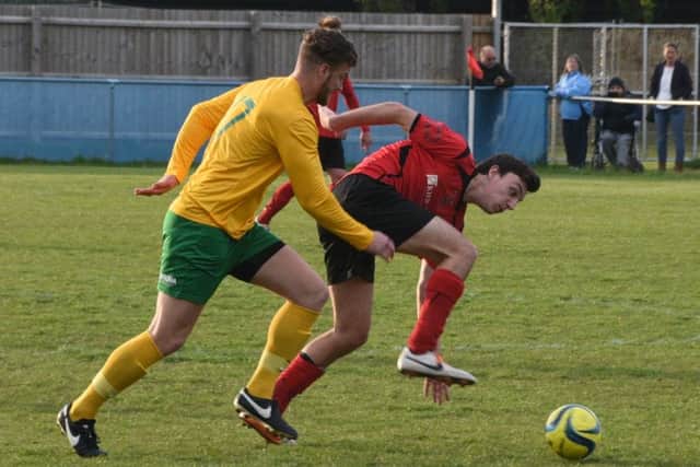 Oakham substitute Alex Brown muscles his way past Chris Hansford of Netherton. Photo: David Lowndes.