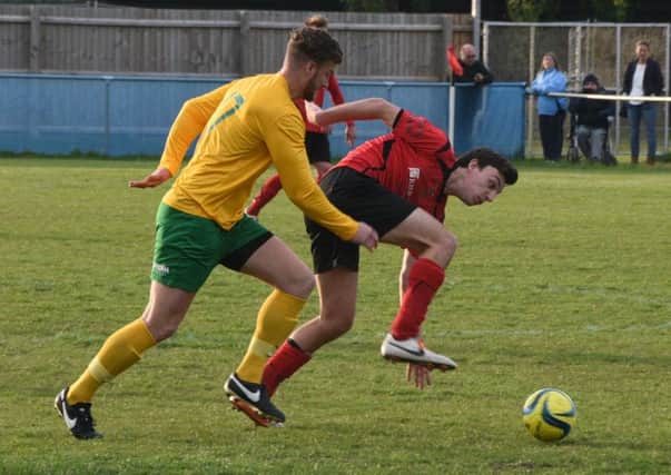Oakham substitute Alex Brown muscles his way past Chris Hansford of Netherton. Photo: David Lowndes.