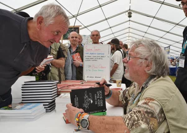Birdfair 2015 at Rutland water.  One of  the celebrities at the event  Bill Oddie signing book for Anthony Skyrme EMN-150821-174118009
