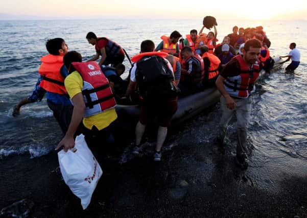 Refugees in a rubber dinghy arriving on the beach at Psalidi on Kos aecd6113-4790-48d2-a3c5-fa68b3b6