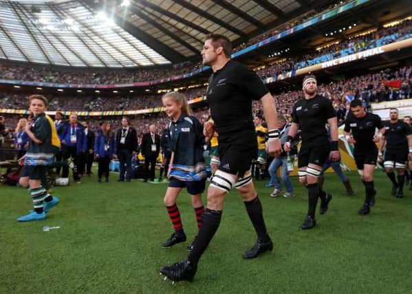 New Zealand captain Richie McCaw walks out for the Rugby World Cup final at Twickenham with Brooke Felming. 
Photo: David Davies/PA Wire. EMN-150311-155929001