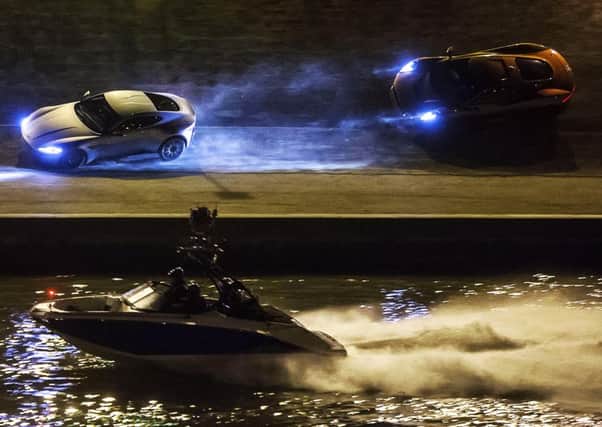 A Scarab jet boat provided by 158 Performance in Tallington films a Jaguar as it runs after an Aston Martin along the Tiber River banks during the shooting of the James Bond movie Spectre in Rome.. Photo: AP/Angelo Carconi, Ansa EMN-150411-102111001