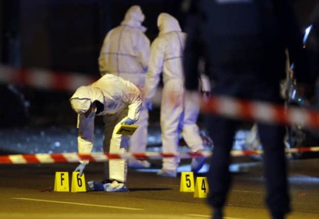 Investigating police officers work outside the Stade de France stadium. Picture: AP