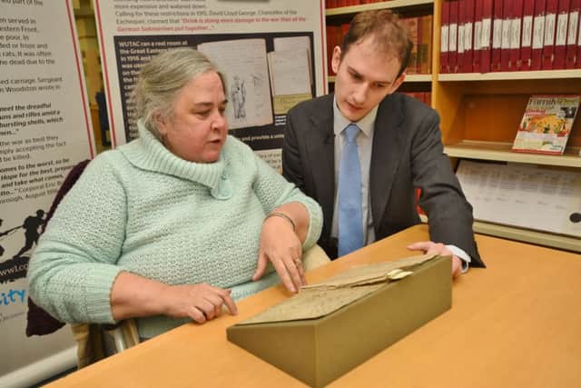 Joy Coster looking at the army records from the old East Station during the war where her father wrote a message. Also pictured is Central Library archives manager Richard Hunt EMN-161201-172434009