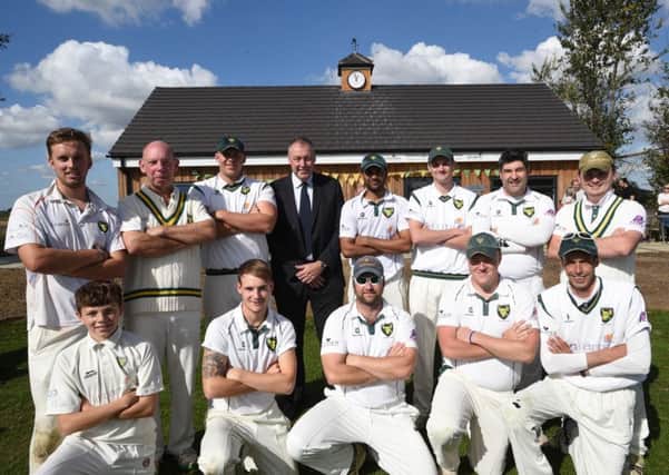 Players from Newborough Cricket Club pose with former England star Angus Fraser in front of a pavilion that was opened last September.