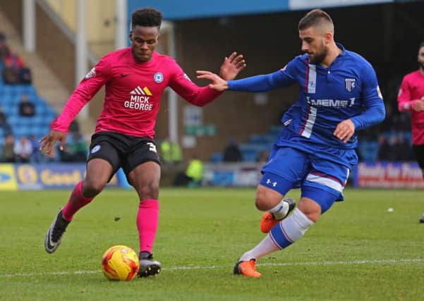 Posh debutant Shaquille Coulthirst tries to find a way past Gillingham defender Max Ehmer. Photo: Joe Dent/theposh.com.
