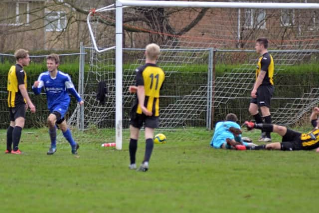 Ollie Maltby (blue) has just scored for Moulton Harrox against Holbeach Reserves. He went on to get a hat-trick. Photo: Tim Wilson.