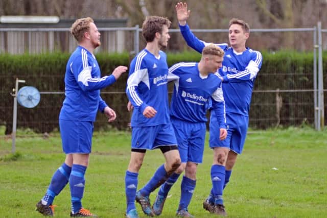 Ollie Maltby (second left) is congratulated after scoring one of his hat-trick goals against Holbeach United Reserves. Photo: Tim Wilson.