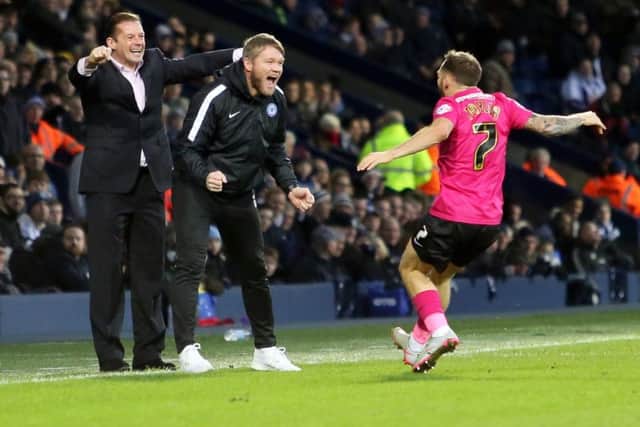 Jon Taylor of Peterborough United rushes to celebrate his goal with Peterborough United manager Graham Westley and assistant manager Grant McCann. Picture: Joe Dent