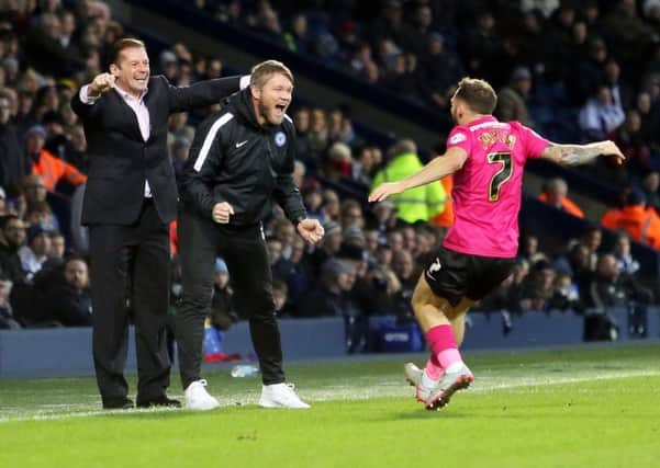 Jon Taylor of Peterborough United rushes to celebrate his goal with Peterborough United manager Graham Westley and assistant manager Grant McCann. Picture: Joe Dent