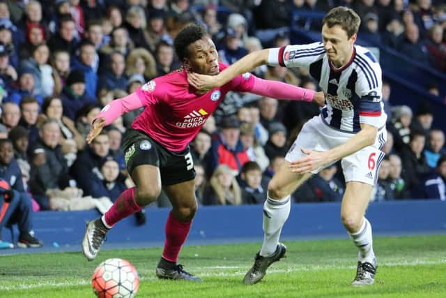 Shaquile Coulthirst of Peterborough United is held back by Jonny Evans of West Bromwich Albion. Picture: Joe Dent