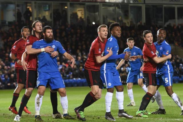 Posh players Michael Bostwick (left), Shaquile Coulthirst (centre) and Gaby Zakuani (right) are closely marked at a home corner against West Brom. Photo: David Lowndes.