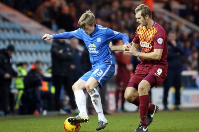 Second-half Posh substitute Chris Forrester holds of two-goal Bradford star James Hanson. Photo: Joe Dent/theposh.com.