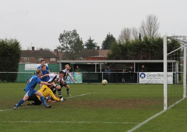 Luke Smith (stripes) scores for Peterborough Northern Star in their defeat at home to Cogenhoe. Photo: Tim Gates.