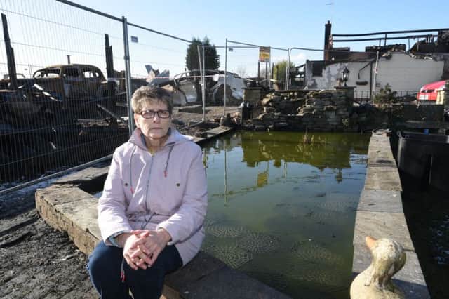 Sue Dolby outside her fire damaged home