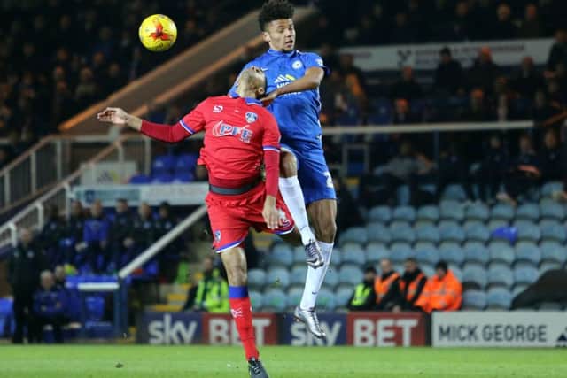 Posh striker Lee Angol out-jumps Oldham's Timothee Dieng. Photo: Joe Dent/theposh.com.