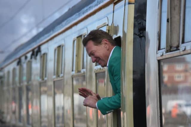 Michael Portillo waving to the crowd at Peterborough Station on-board the Flying Scotsman