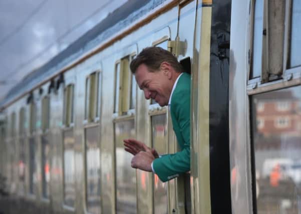 Michael Portillo waving to the crowd at Peterborough Station on-board the Flying Scotsman