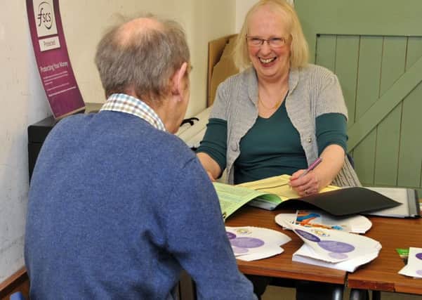 Volunteer Jane Francis sees a client at The Reading Rooms, Holbeach, one of six access points in the county for Lincolnshire Credit Union.  Photo by Tim Wilson.