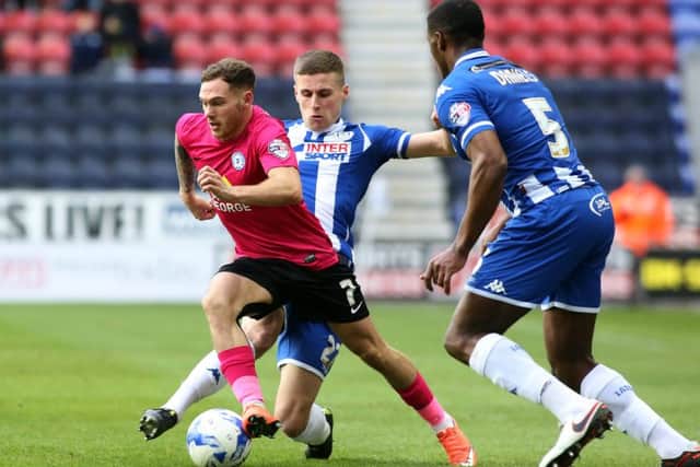 Jon Taylor of Peterborough United skips past Ryan Colclough of Wigan Athletic. Picture: Joe Dent