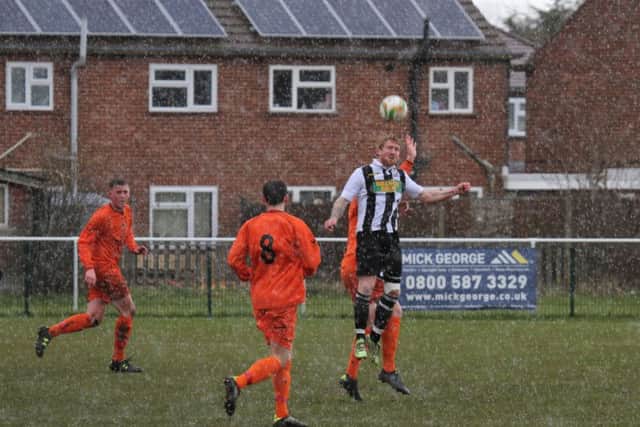 Craig Smith wins  a header for Peterborough Northern Star against Oadby.