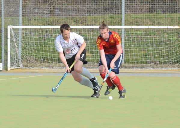 Ross Ambler (red) of City of Peterborough in action against Wapping. Photo: David Lowndes.