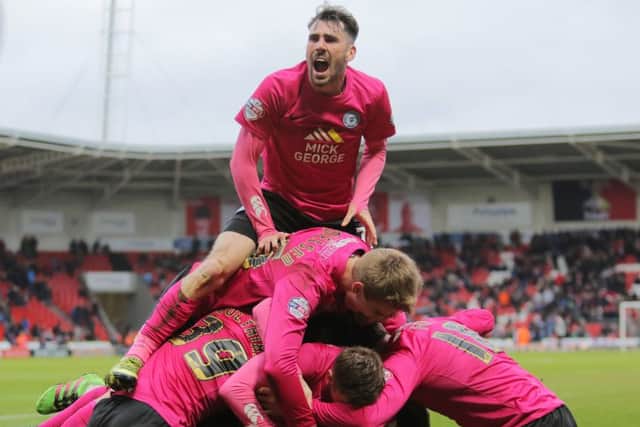 Michael Smith is on top of the heap as Posh celebrate the winning goal at Doncaster. The scorer Ricardo Santos is at the bottom somewhere. Photo: Joe Dent/theposh.com.