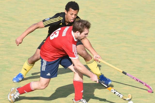 Joe Finding of City of Peterborough passes the ball out of defence while under pressure from a Beeston opponent. Photo: David Lowndes.