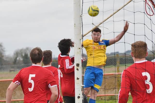 Action from Langtoft United's PFA Cup semi-final win over Stamford Lions. Langtoft are in red. Photo: David Lowndes.