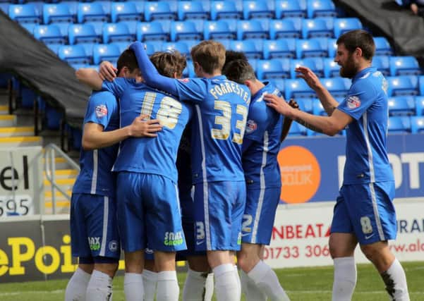 Posh midfielder Harry Beautyman is engulfed by team-mates after opening the scoring against Crewe. Photo: Joe Dent/theposh.com.