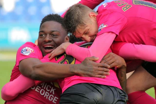 Posh striker Shaquile Coulthirst is at the centre of these celebrations after scoring at Colchester. Photo: Joe Dent/theposh.com.