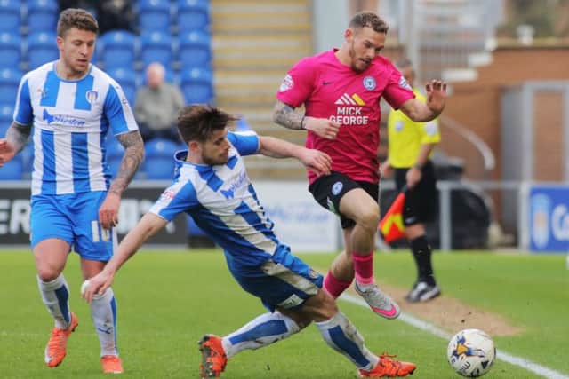 Jon Taylor of Posh tries to skip past Colchester's Joe Edwards. Photo: Joe Dent/theposh.com.