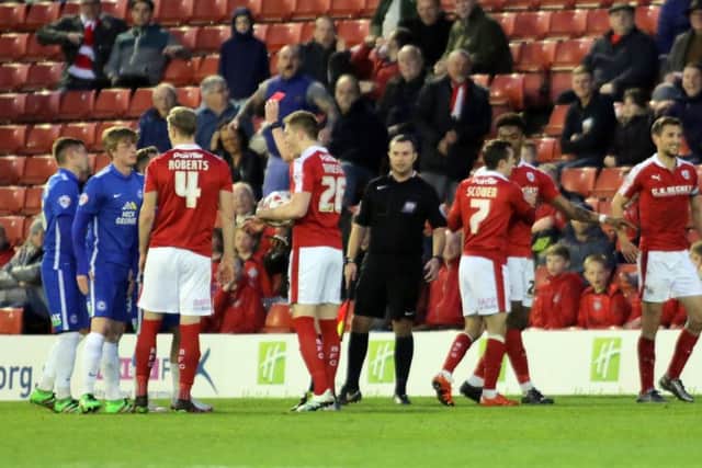 Barnsley's Conor Hourihane (right) is all smiles as Posh midfielder Chris Forrester is shown a red card. Photo: Joe Dent/theposh.com.