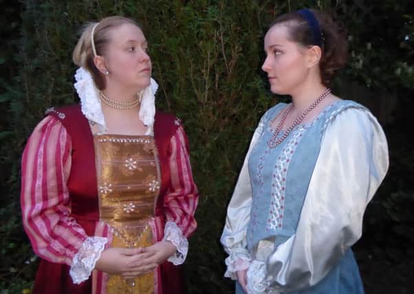 Queen Elizabeth (Ami Walsh) frowning with disapproval at her maid Bessie (Laura Hobbs).