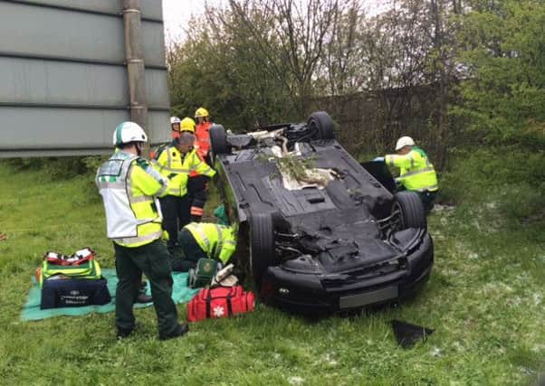 Fire crews working to release the trapped casaulty from the overturned car. Photo: Cambs Fire and Rescue