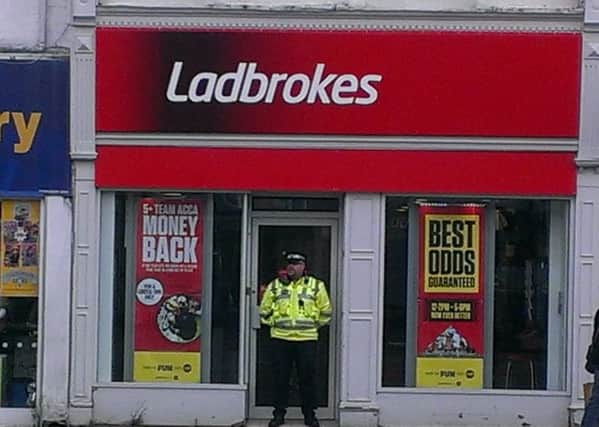 A police guard outside Ladbrokes in Hall Place, Spalding, after a robbery took place there on Thursday morning.