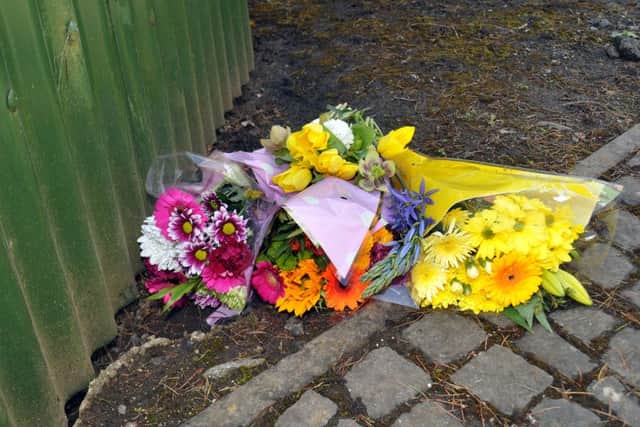 Flowers close to the scene of the fire that claimed three lives. SG030516-104TW