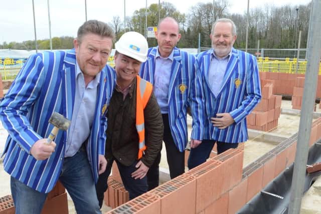 Andy Moore, Malcolm Larrington and Mike Marjoram, wearing new Lions blazers, are pictured on the site of the club's new changing rooms with  James Brackenbury from construction companny GKL.