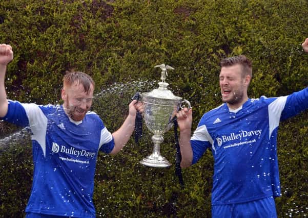 Moulton Harrox players Bobby Patterson (left) and Ashley Coddington (right) with the Peterborough Premier Division trophy.