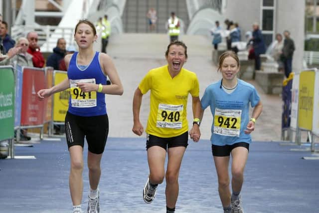 Terminally-ill cancer sufferer Jane Tomlinson (centre) finishes the 'People's Race' at the Salford Triathlon World Cup with her daughters Rebecca (right) and Suzanne (left, Salford Quays, Manchester. Pic Martin Rickett/PA. Unique Reference No. 2006106 ... SOCIAL Tomlinson 6