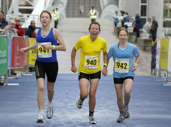 Terminally-ill cancer sufferer Jane Tomlinson (centre) finishes the 'People's Race' at the Salford Triathlon World Cup with her daughters Rebecca (right) and Suzanne (left, Salford Quays, Manchester. Pic Martin Rickett/PA. Unique Reference No. 2006106 ... SOCIAL Tomlinson 6