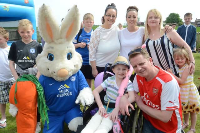 Peter Burrows with Rico Dunworth (8)at a fundraising event at Eastrea village hall with family members and event organisers EMN-160705-165308009